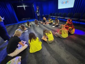 Brownies sit around in a circle working on projects